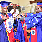Überreichung der Universitäts-Insignien durch den Rektor Alexis Mpoyi stellvertretend an den Secrétaire Général Académique Guy Octave Lutumba.