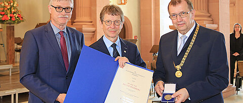 Nach der Verleihung der Verdienstmedaille: Dieter Mahsberg (M.) mit Laudator Unikanzler Uwe Klug und Unipräsident Alfred Forchel (r.)