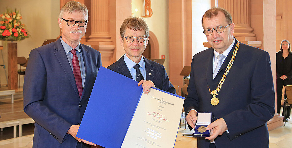 Nach der Verleihung der Verdienstmedaille: Dieter Mahsberg (M.) mit Laudator Unikanzler Uwe Klug und Unipräsident Alfred Forchel (r.)