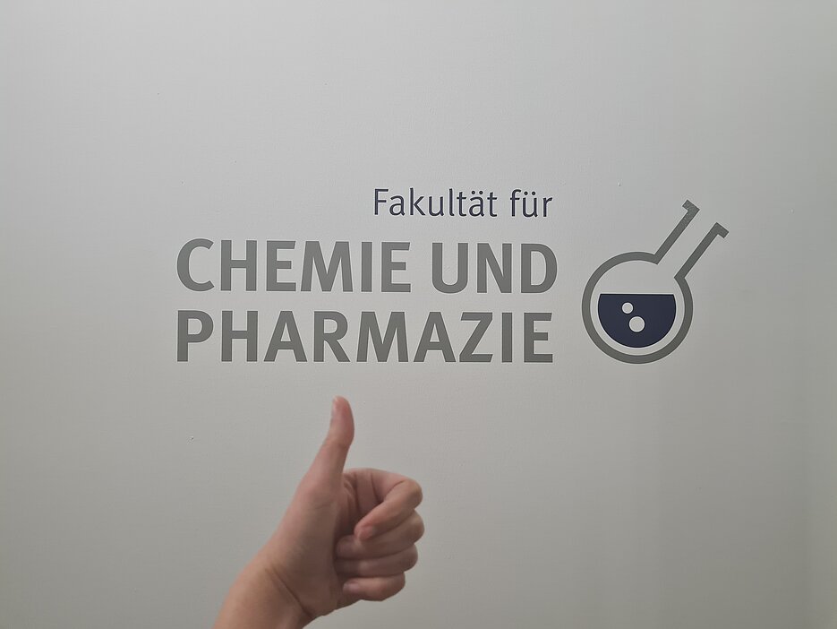 Die Fakultät für Chemie und Pharmazie Logo mit Daumen-hoch-Symbol