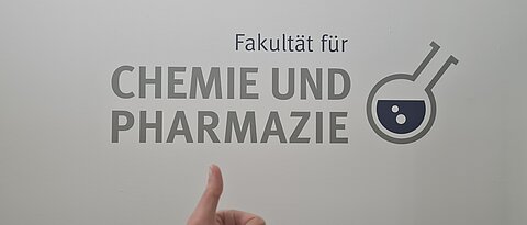Die Fakultät für Chemie und Pharmazie Logo mit Daumen-hoch-Symbol