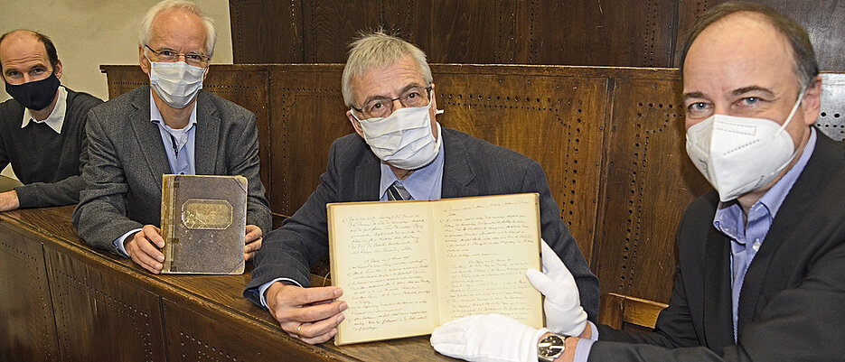 Übergabe der handschriftlichen Protokollbände im historischen Röntgen-Hörsaal der FHWS. Im Bild (v.l.): Utz Fischer, Manfred Gessler und Manfred Schartl von der PMG sowie Hans-Günter Schmidt, Leiter der UB. 