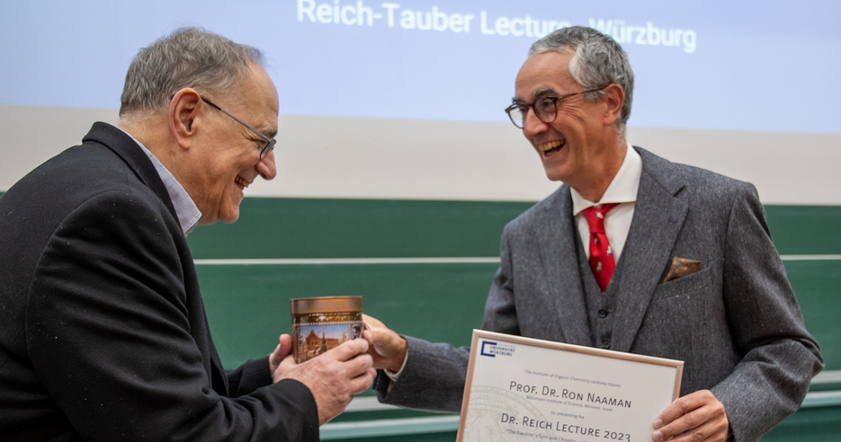 Vergnügte Mienen bei der Übergabe von Urkunde und Gastgeschenk an Prof. Ron Naaman (l.) durch Prof. Christoph Lambert (Foto: C. Stadler)