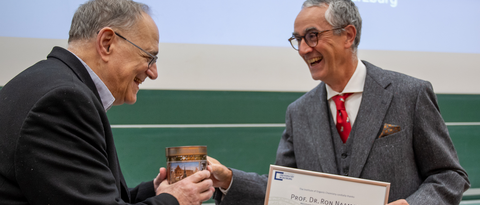 Vergnügte Mienen bei der Übergabe von Urkunde und Gastgeschenk an Prof. Ron Naaman (l.) durch Prof. Christoph Lambert (Foto: C. Stadler)