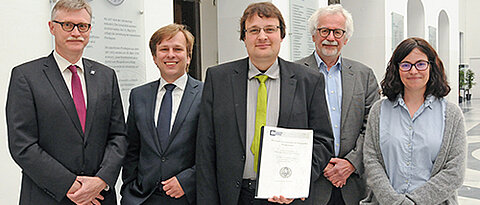 Mit dem PROMI-Absolventen Dr. Bernhard Schneider (Mitte) freuen sich (von links) Unikanzler Uwe Klug, Axel Winkelmann, Jürgen Tautz und Sandra Mölter. (Foto: Robert Emmerich)
