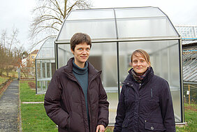 Caroline Müller (links) und Franziska Kuhlmann vom Biozentrum der Uni Würzburg vor den neuen Spezial-Gewächshäusern. Darin wollen die Forscherinnen prüfen, ob UV-Licht die Widerstandsfähigkeit von Nutzpflanzen gegen Schädlinge steigert. Foto: Rober